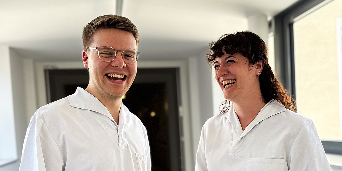Eine Pflegerin und ein Pfleger lachen gemeinsam